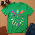 A bright green short-sleeve t-shirt laid flat on a cork surface, featuring a colorful graphic of various socks and the text 'ROCK YOUR SOCKS Down Syndrome Awareness.' Surrounding props include a coffee cup, an apple, a notebook, and blue jeans.