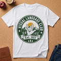 White flat lay t-shirt says "Visual Language Club, Est 1817' surrounding a badge style graphic of an ASL hand gesture of Love with a Mountain sunset behind it.  This tee uses a lot of negative space.  