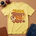 YELLOW T-SHIRT SAYS MAKING HISTORY FUN AGAIN' WITH A GLOBE AND INK QUILL GRAPHIC.