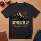 Black T-Shirt Graphic of a man hiking on a Mountain next to a compass symbol rising out of a pine forest.  Underneath it reads "Never Give Up, Keep Moving Forward, Progress over Perfection"