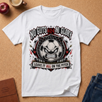 A white short-sleeve graphic T-shirt laid flat on a cork surface, surrounded by lifestyle props including an apple, a mug, a journal, and jeans. The shirt features a large black, red, and gray sports-themed graphic with the text 'No Guts 4:49 Glory' and 'Leave It All On The Pitch.