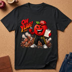 A black graphic t-shirt laid flat on a brown cork background, featuring a cartoon red apple character wearing a 'GyM Teacher' cap and sweatpants, with the text 'OH YEAH!' and a clipboard.
