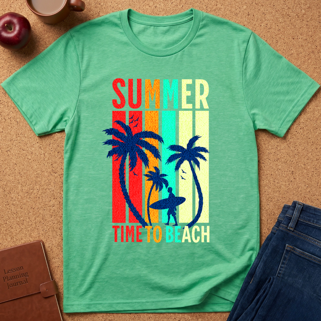 A mint green heather t-shirt laid flat on a cork background, featuring a retro vertical-stripe graphic with palm trees, a surfer silhouette, and the text 'SUMMER TIME TO BEACH' in multicolor letters. Styled flat-lay props include an apple, a notebook, and blue jeans.