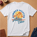 A white short-sleeve crewneck t-shirt laid flat on a cork board background, featuring a colorful retro graphic of palm trees, a yellow-orange sun, and blue text that reads 'SUMMER VACATION & Positive Vibes'.