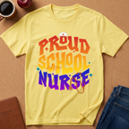 A yellow graphic t-shirt laid flat on a cork background, surrounded by lifestyle props including a coffee cup, an apple, a notebook, and folded blue jeans. The shirt features a colorful retro-style graphic that reads 'PROUD SCHOOL NURSE' in orange, yellow, and purple lettering with a stethoscope and nurse hat illustration.