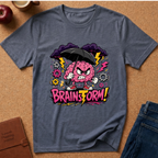 A heathered blue-gray t-shirt laid flat on a cork background, featuring a colorful graphic of an angry pink brain holding a black umbrella with the text 'BRAINSTORM!'.