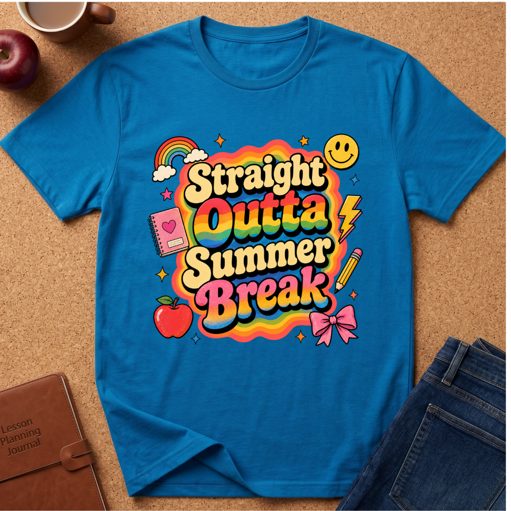 A bright blue graphic T-shirt laid flat on a cork surface, surrounded by styled props including an apple, coffee cup, notebook, and jeans. The shirt features a large colorful retro-style text graphic reading 'Straight Outta Summer Break' with rainbow, smiley face, lightning bolt, notebook, apple, pencil, and bow tie illustrations.