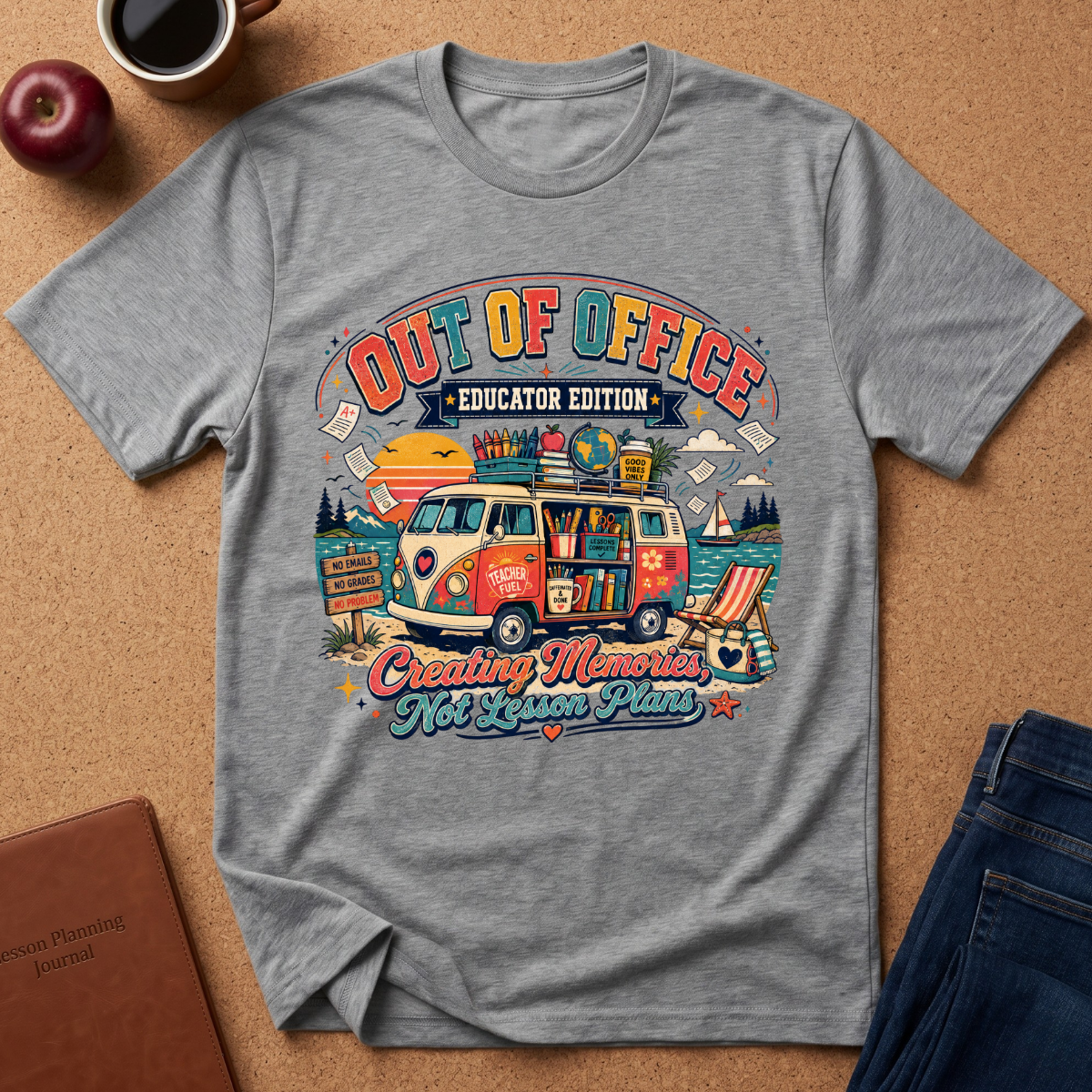 A heather gray graphic t-shirt laid flat on a cork background, featuring a colorful retro-style illustration of a VW bus and the text 'OUT OF OFFICE EDUCATOR EDITION' and 'Creating Memories Non-Lesson Plans'.