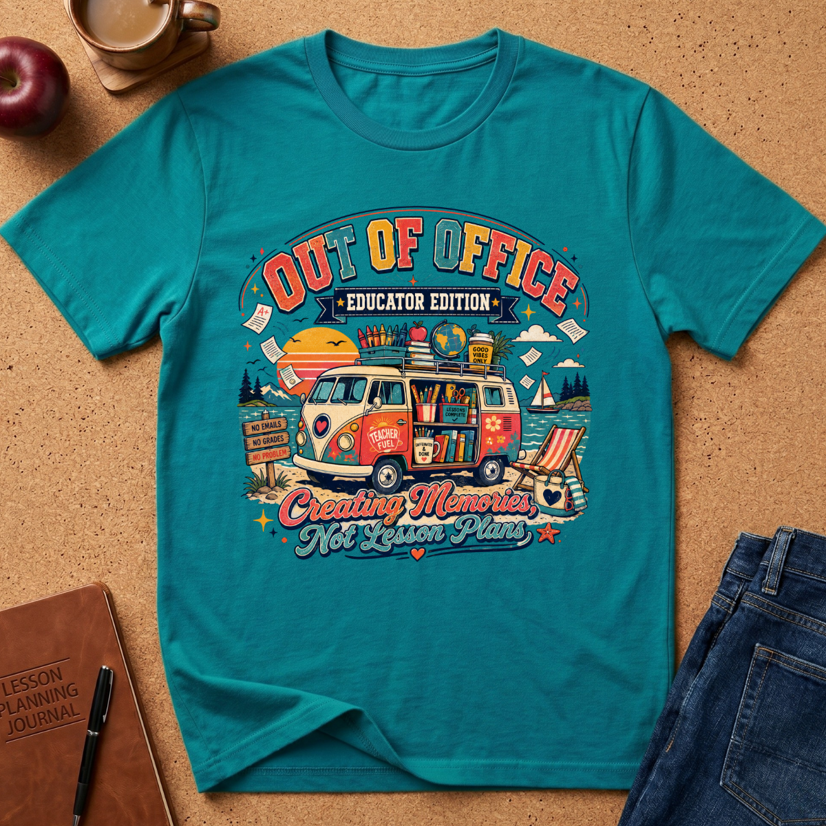 A teal graphic t-shirt laid flat on a cork surface, surrounded by lifestyle props including a coffee mug, apple, notebook, and jeans. The t-shirt features a colorful retro-style illustration of a VW bus with school supplies and the text 'OUT OF OFFICE EDUCATOR EDITION' and 'Creating Memories Not Labor Plans'.