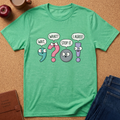A green graphic t-shirt laid flat on a cork background, featuring cartoon characters and speech bubbles that read 'WAIT.', 'WHAT?', 'STOP IT.