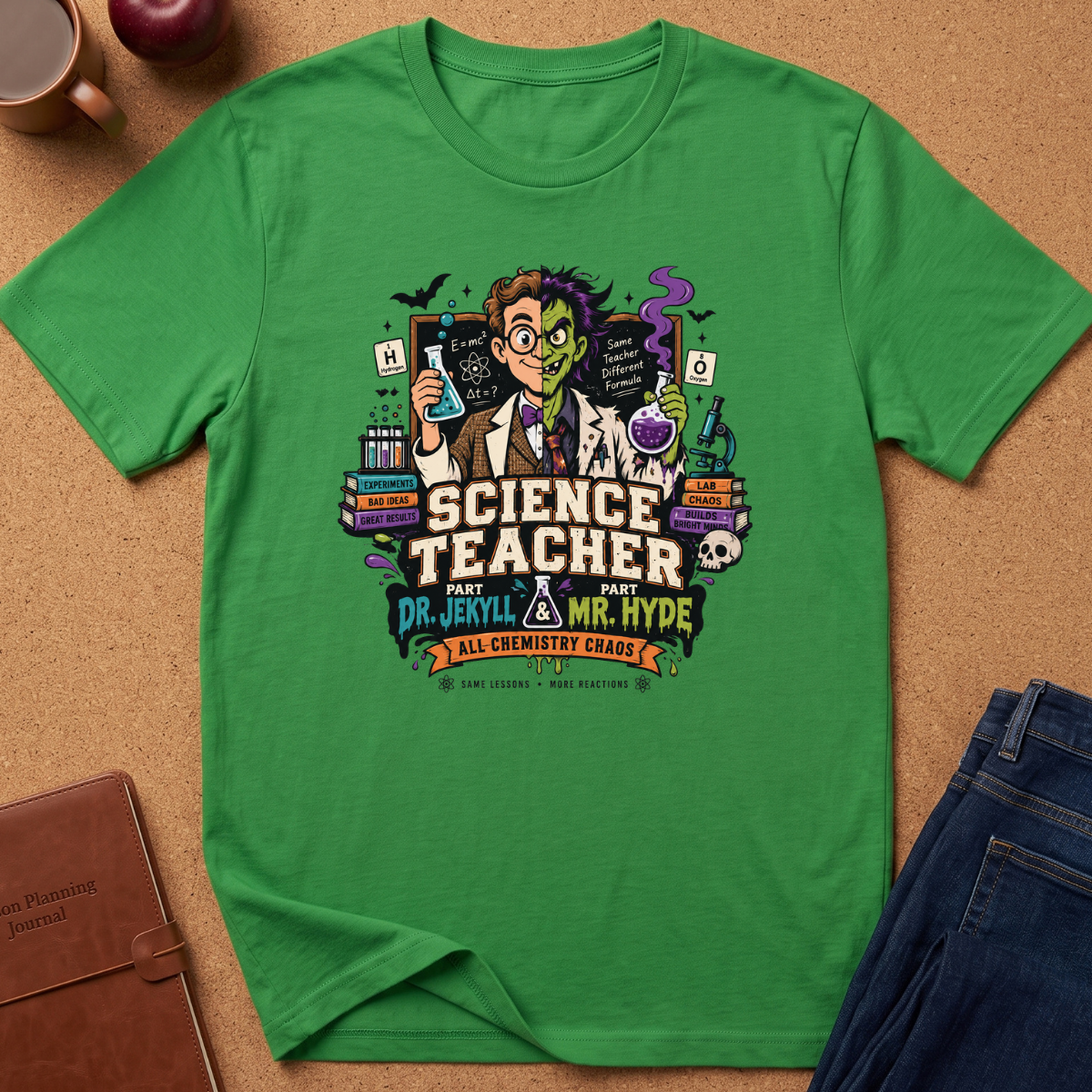 A green short-sleeve graphic T-shirt laid flat on a cork surface, featuring a colorful retro illustration of a nerdy science teacher with chalkboard and lab equipment, plus the text 'SCIENCE TEACHER AND DR. JERKLY MR.