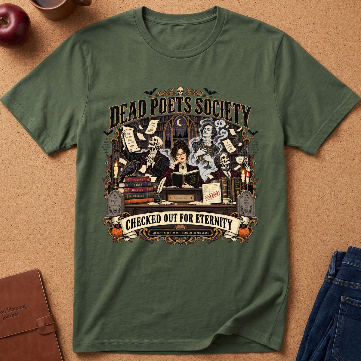 An olive green short-sleeve t-shirt with a detailed Halloween-themed graphic print featuring skeletons, books, and the text 'Dead Poets Society' and 'Checked Out for Eternity', laid flat on a cork background with lifestyle props.