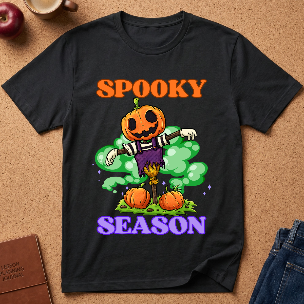 Black Spooky Season Pumpkin T-Shirt pairs a grinning jack-o’-lantern rising through green mist with scattered pumpkins and bold retro “SPOOKY SEASON” lettering. 