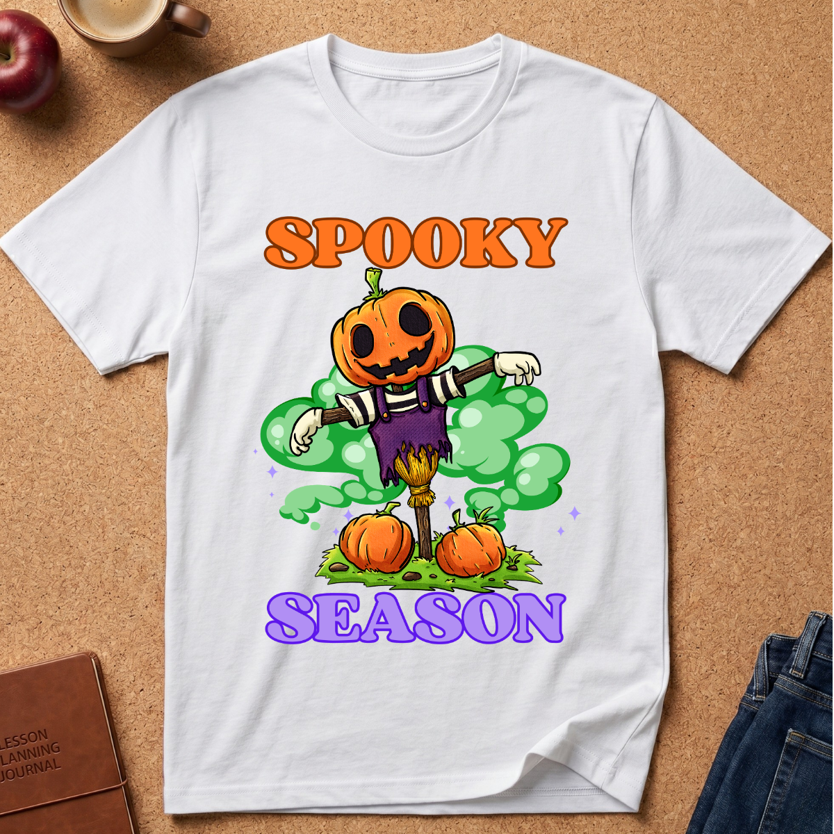 White Spooky Season Pumpkin T-Shirt pairs a grinning jack-o’-lantern rising through green mist with scattered pumpkins and bold retro “SPOOKY SEASON” lettering. 