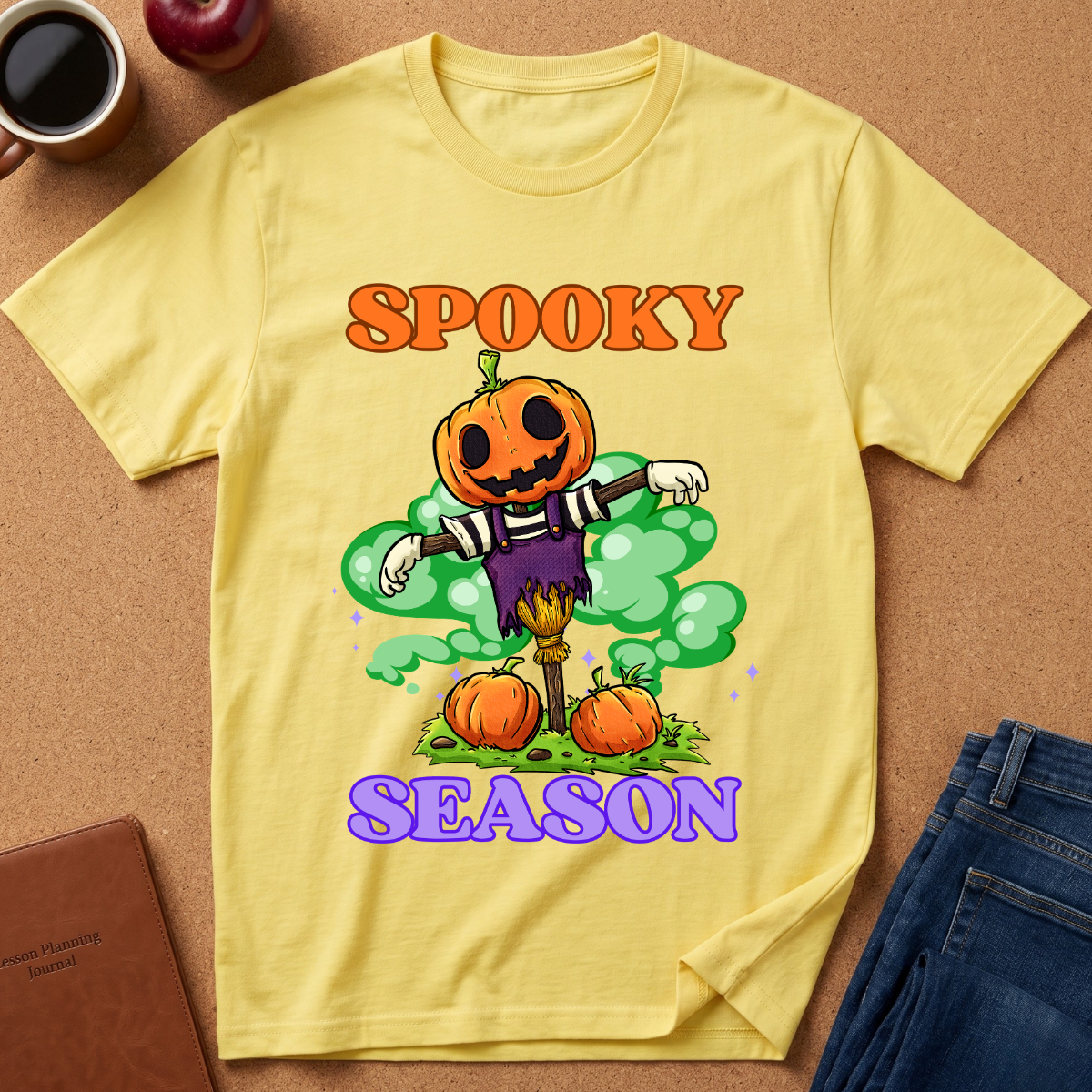Yellow Spooky Season Pumpkin T-Shirt pairs a grinning jack-o’-lantern rising through green mist with scattered pumpkins and bold retro “SPOOKY SEASON” lettering. 