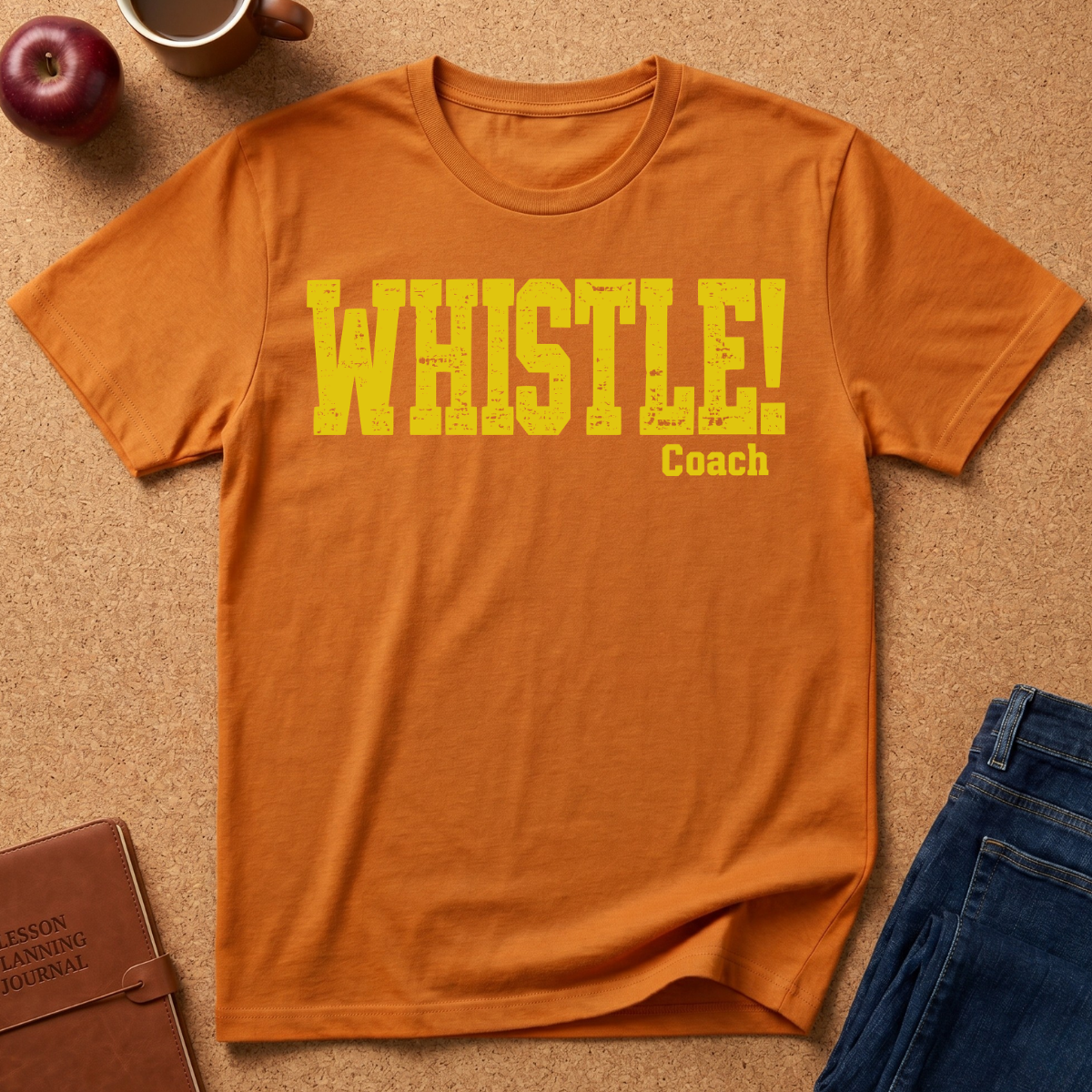 Orange Graphic Tee With the text "WHISTLE!" in a distressed yellow font, and then a second line saying "Coach" in a smaller script.