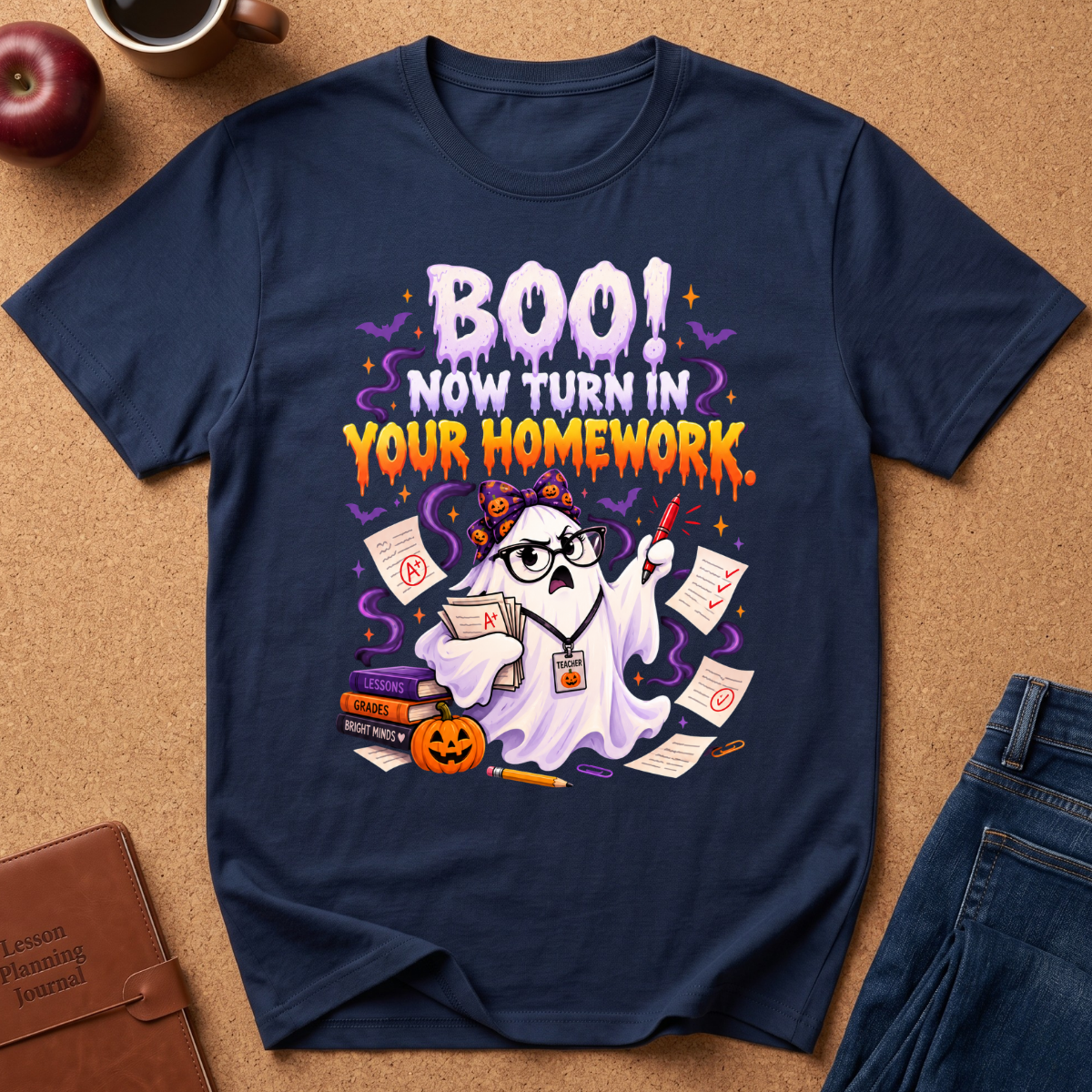 Navy blue Graphic short sleeves T-Shirt with a cute ghost looking upset with a red pen and a pile of gra Ed homework, saying BOO, Now Turn In Your Homework.
