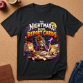 A black graphic t-shirt laid flat on a cork background, featuring a colorful cartoon illustration of a zombie librarian surrounded by books and the text 'The Nightmare Before Report Cards'.