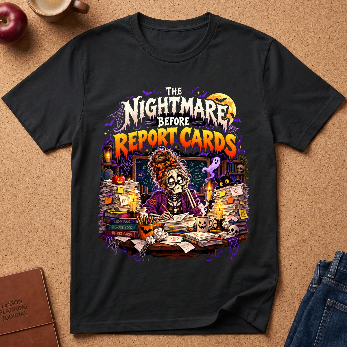 A black graphic t-shirt laid flat on a cork background, featuring a colorful cartoon illustration of a zombie librarian surrounded by books and the text 'The Nightmare Before Report Cards'.