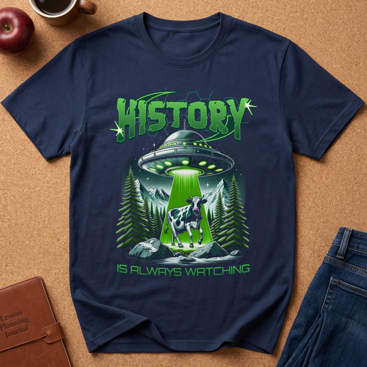 A Navy blue graphic T-shirt with a UFO abducting a cow from a mountain valley, with a green light.  The text reads History is always watching.