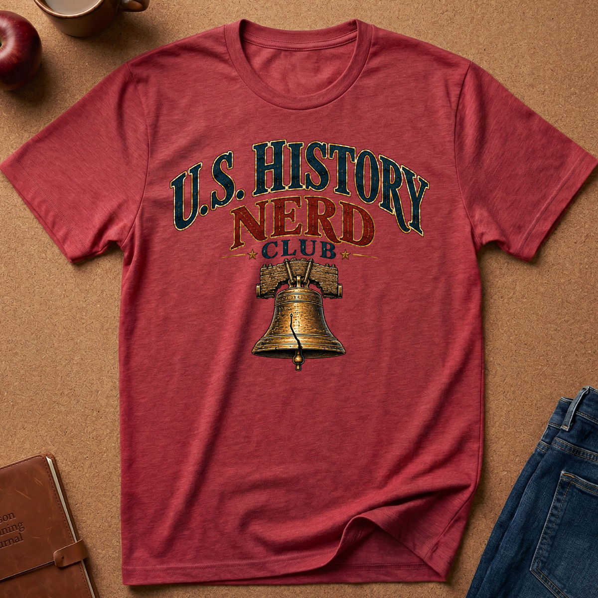 A heathered red crewneck t-shirt with a vintage-style graphic reading 'U.S. History Nerd Club" With an image of the liberty bell.
