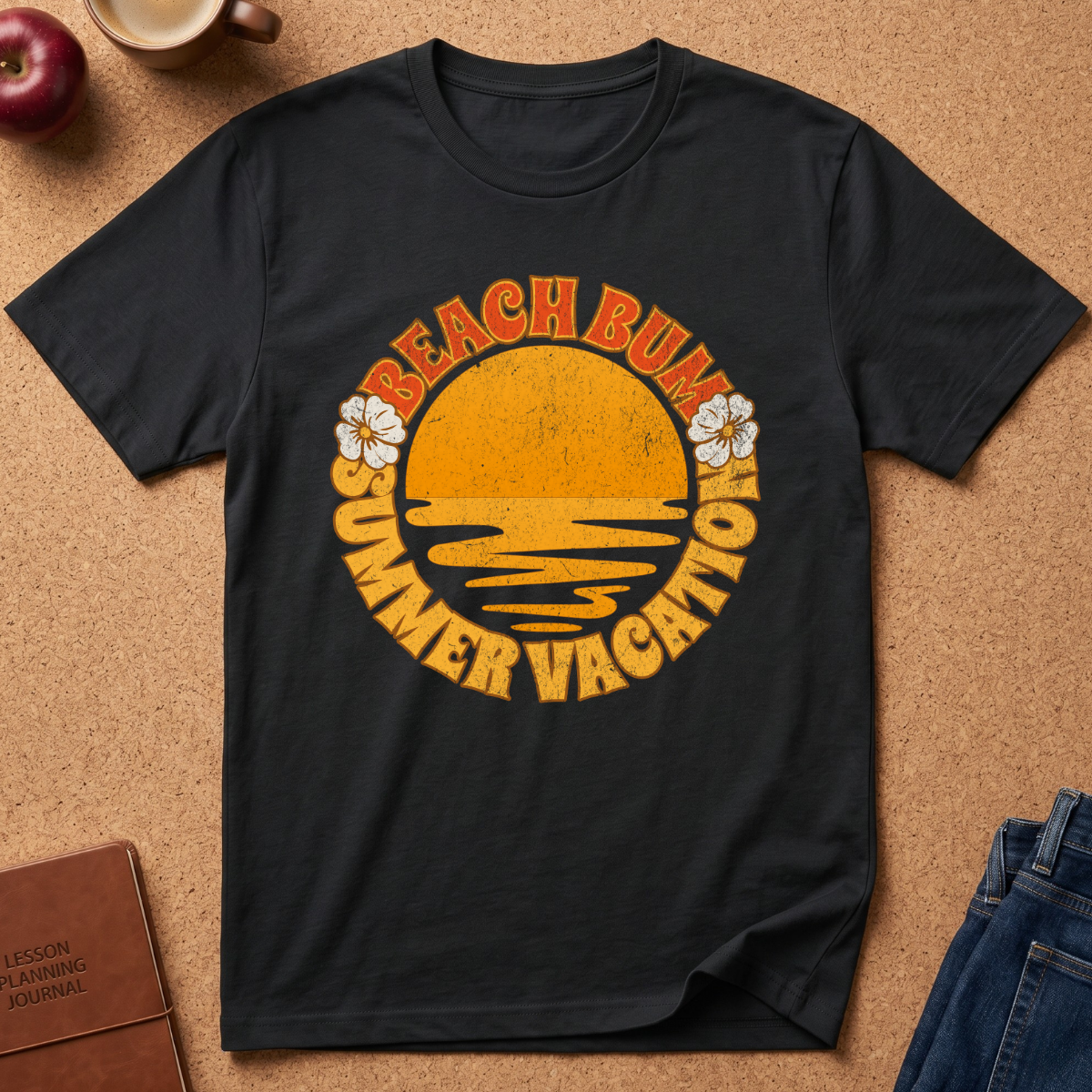 A black short-sleeve t-shirt laid flat on a cork background, featuring a retro-style yellow and orange graphic with the words 'BEACH BUM SUMMER VACATION' and small white flower illustrations.