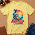 A yellow short-sleeve t-shirt with a colorful retro 'Summer Vacation' IS A STATE OF MIND graphic, laid flat on a cork background with lifestyle props including a coffee mug, apple, notebook, and jeans