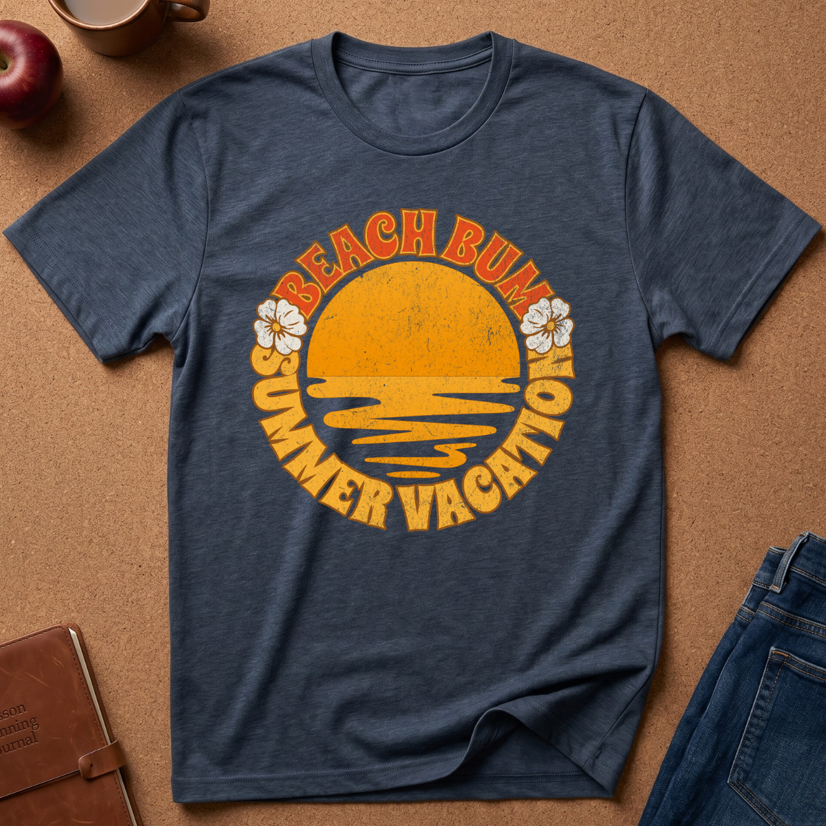 Heather Navy short-sleeve t-shirt laid flat on a cork background, featuring a retro-style yellow and orange graphic with the words 'BEACH BUM SUMMER VACATION' and small white flower illustrations.