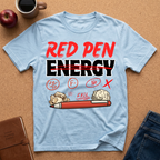 Light blue graphic t-shirt with 'Red Pen Energy' with '20/50, F minus, No, Fail and X" scattered with a red pen and crumpled paper graphic design on a brown surface with an apple, coffee, and jeans.