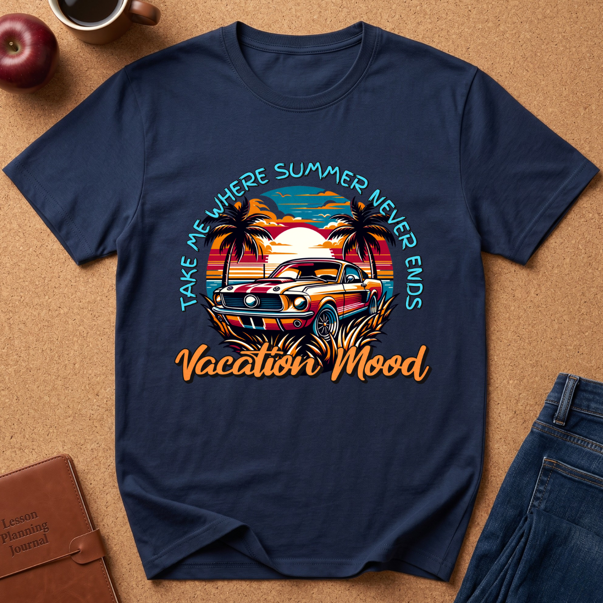 Navy Blue graphic t-shirt laid flat on a cork background, featuring a retro sunset car design with palm trees and the text 'TAKE ME WHERE SUMMER NEVER ENDS Vacation 