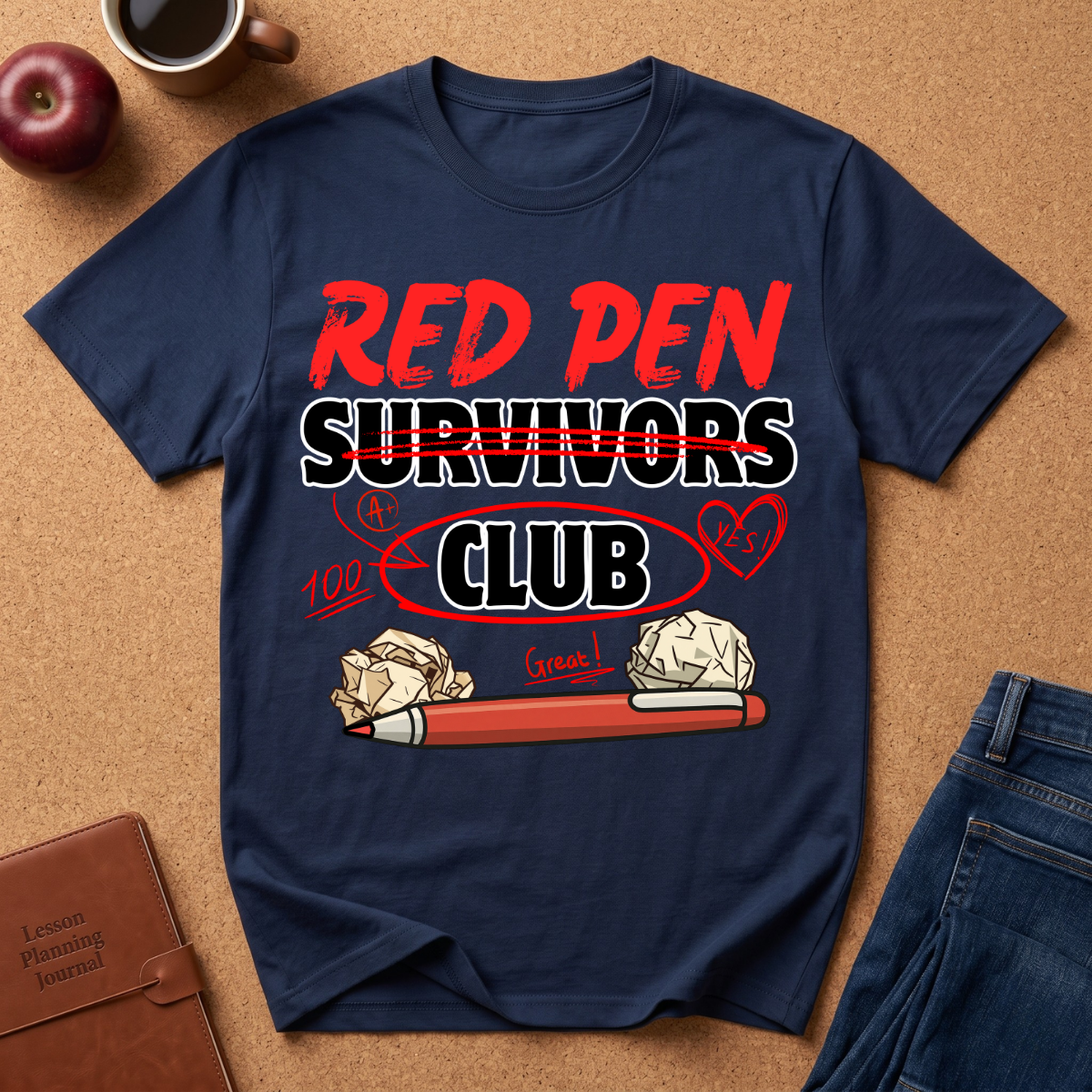 Navy blue t-shirt with 'Red Pen Survivors Club' design on a brown surface with accessories.