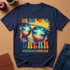 Navy Blue T-Shirt says "We are on a break #SUMMERBREAK" with a graphic image of Sunglasses reflecting a beach sunset.