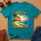 A teal short-sleeve graphic T-shirt laid flat on a cork surface, surrounded by styled props including a coffee cup, apple, notebook, and jeans. The shirt features a colorful tropical beach scene with palm trees and large text reading 'SCHOOL'S OUT FOR SUMMER'.