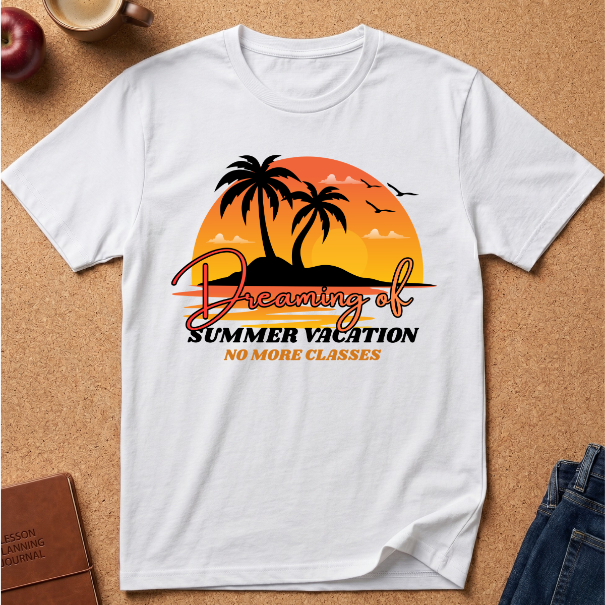 A white short-sleeve t-shirt laid flat on a cork background, featuring a retro-style graphic of two palm trees in front of an orange and yellow sunset with the text 'Dreaming of Summer Vacation NO MORE CLASSES'.