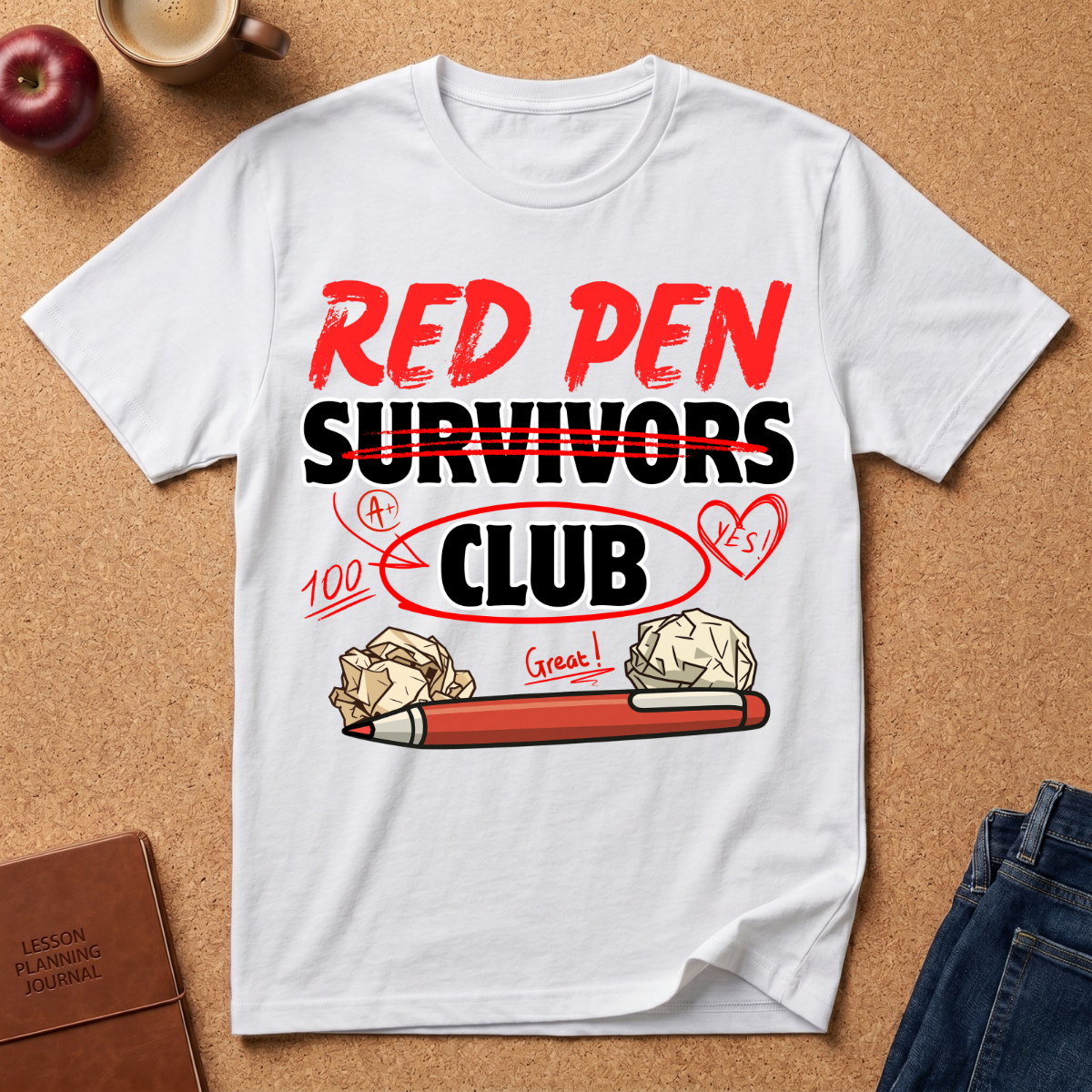 White t-shirt with 'Red Pen Survivors Club' design on a brown surface with accessories.
