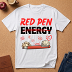 White t-shirt with 'Red Pen Energy' and positive marks graphic on a brown surface with an apple, coffee, and jeans.